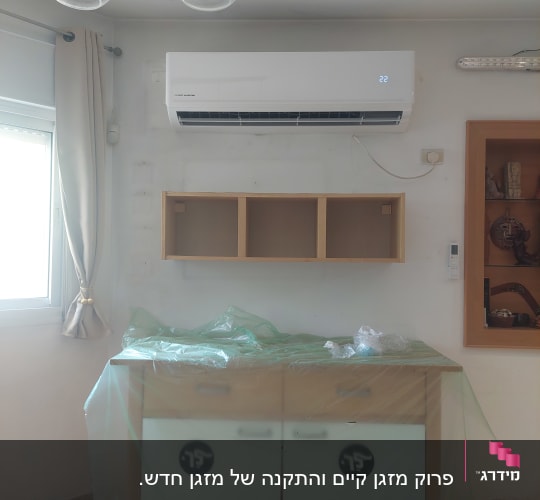 מזגן מותקן על קיר עם תצוגת טמפרטורה דולקת